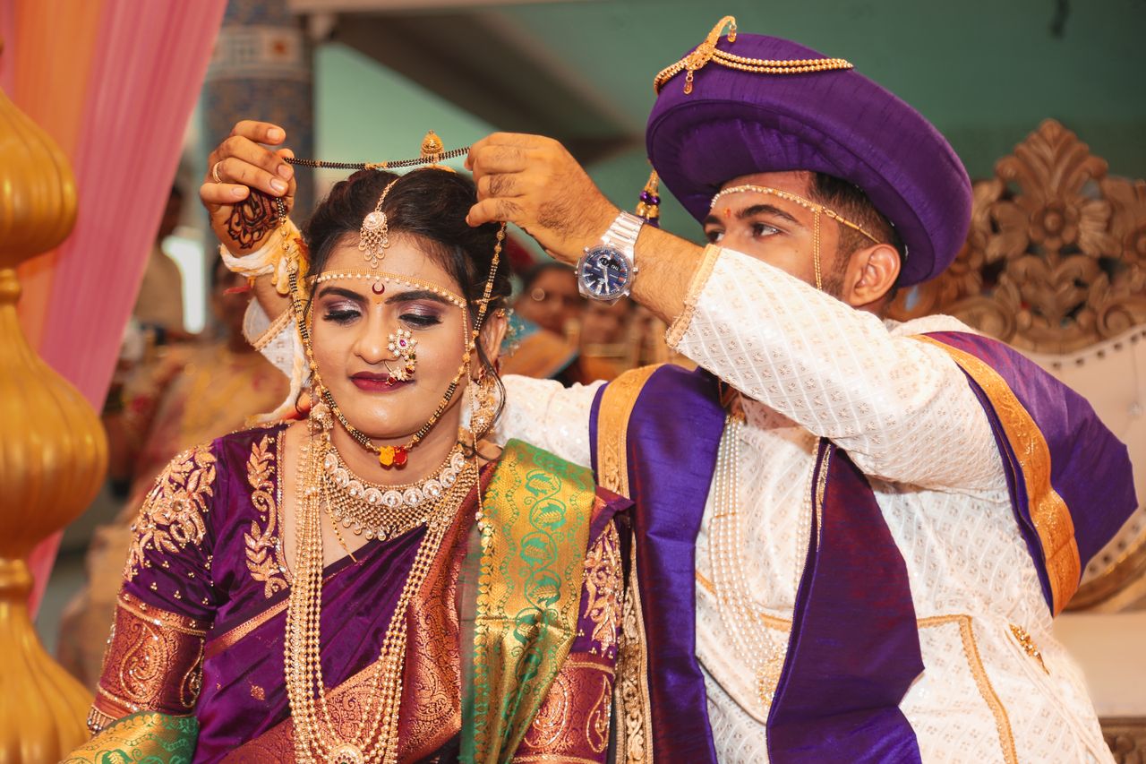 services-01 Bride and groom in traditional attire during an Indian wedding ceremony, exchanging jewelry.