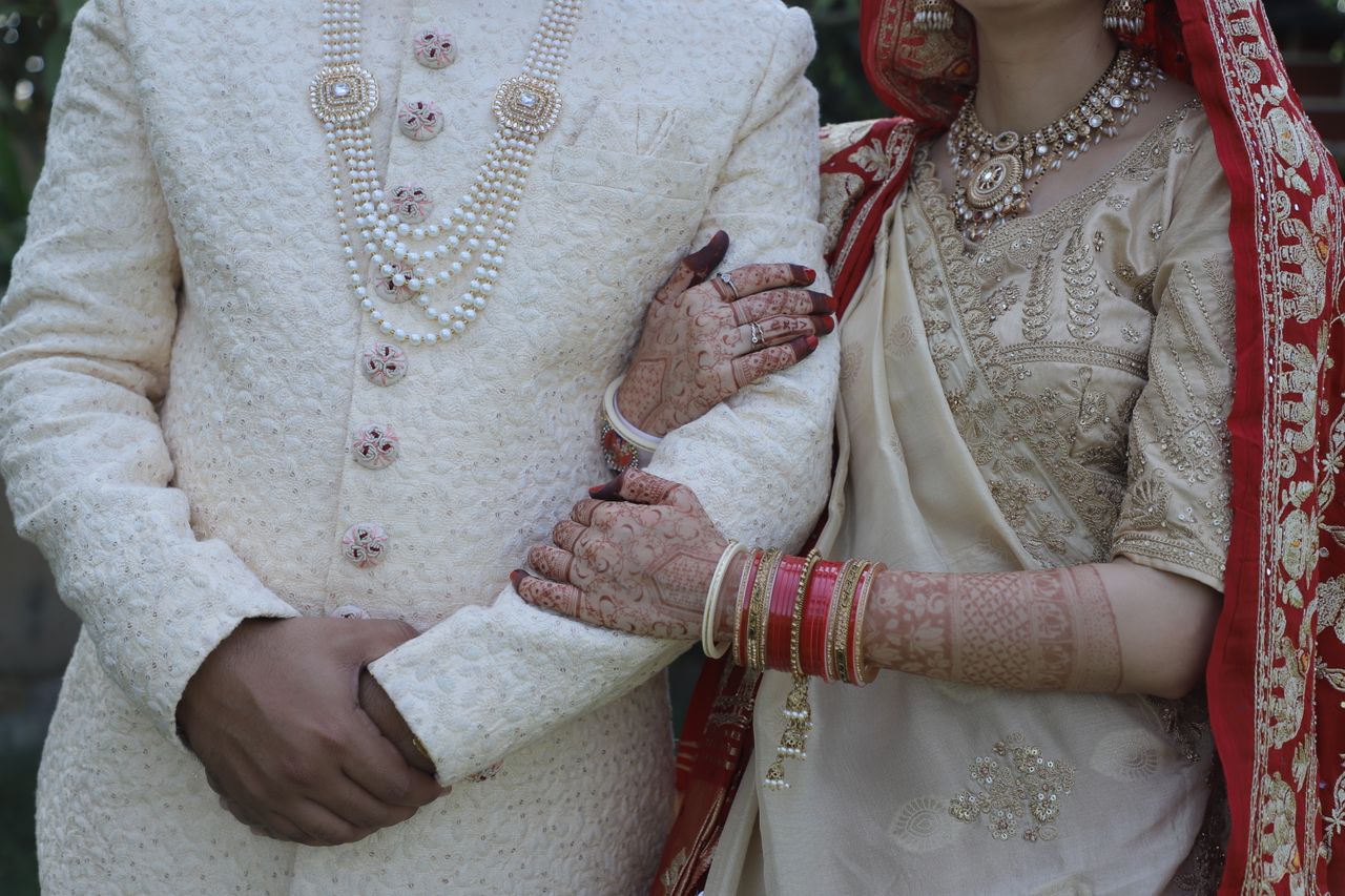 gallery-6 Close-up of an Indian couple in traditional wedding attire during an outdoor ceremony.